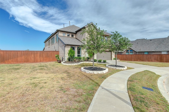 view of front of house with brick siding, fence, driveway, roof with shingles, and a front lawn