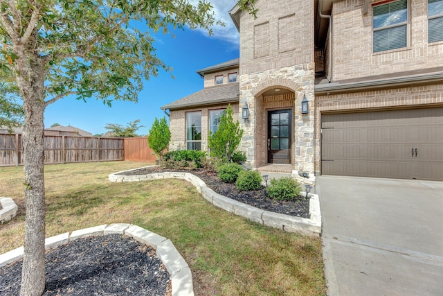 exterior space featuring brick siding, a yard, fence, stone siding, and driveway