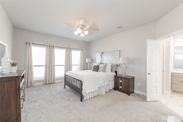 bedroom with light carpet, ensuite bath, visible vents, and baseboards