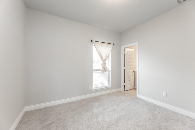 empty room with light carpet, visible vents, and baseboards