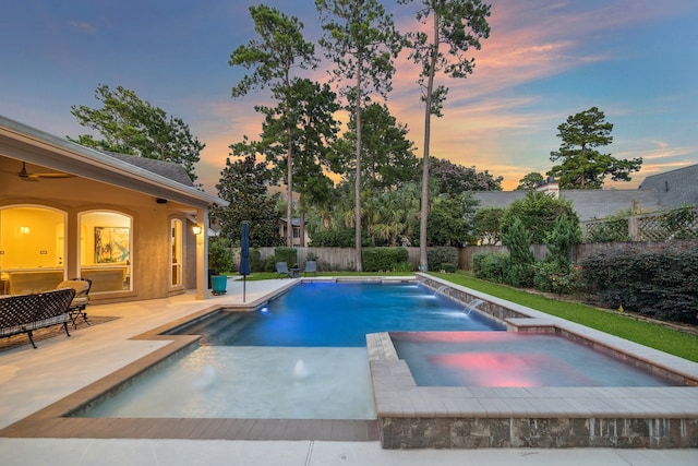 view of swimming pool with a ceiling fan, a pool with connected hot tub, a fenced backyard, and a patio