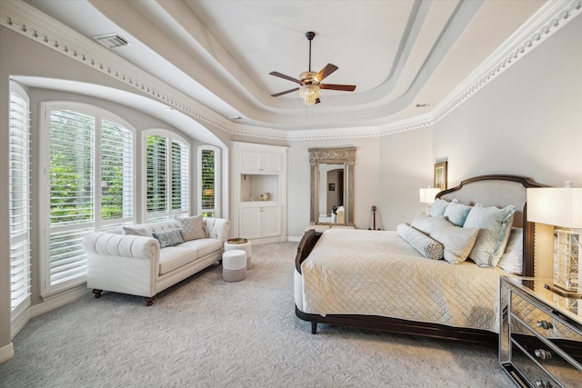 bedroom with light colored carpet, a ceiling fan, baseboards, visible vents, and a raised ceiling