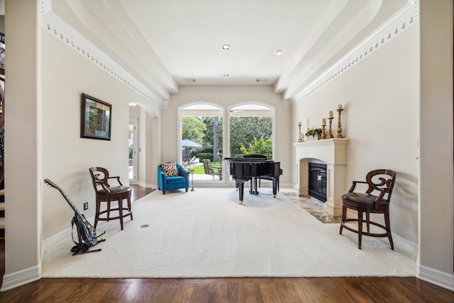 living area featuring a high end fireplace, arched walkways, baseboards, and wood finished floors