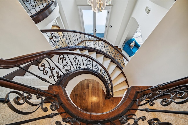 stairs featuring a chandelier and a high ceiling