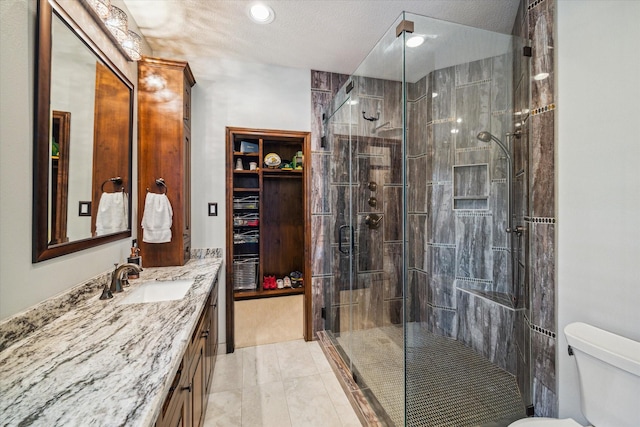 bathroom featuring a stall shower, vanity, and toilet