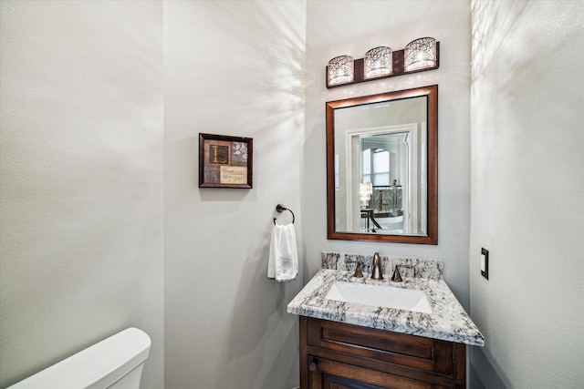 half bathroom with toilet and vanity