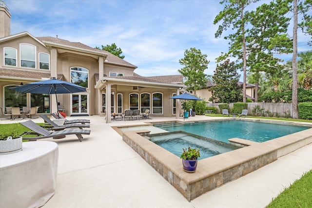 view of swimming pool with a patio, fence, a fenced in pool, and an in ground hot tub