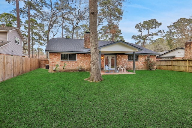 rear view of property with a yard, a patio area, and brick siding