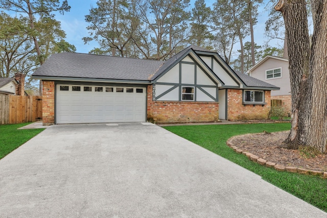 english style home featuring fence, an attached garage, a shingled roof, concrete driveway, and brick siding