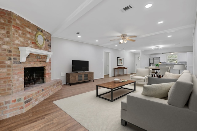 living area with light wood finished floors, visible vents, ceiling fan, recessed lighting, and a fireplace