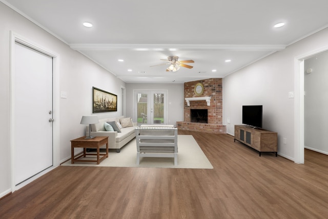 living area featuring wood finished floors, recessed lighting, french doors, a fireplace, and ceiling fan