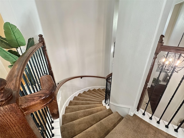 staircase with an inviting chandelier