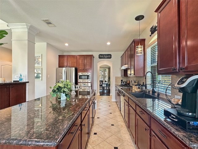 kitchen featuring dark stone countertops, visible vents, a sink, appliances with stainless steel finishes, and backsplash