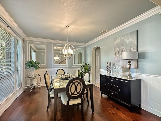 dining room featuring dark wood-style floors, visible vents, arched walkways, and a chandelier