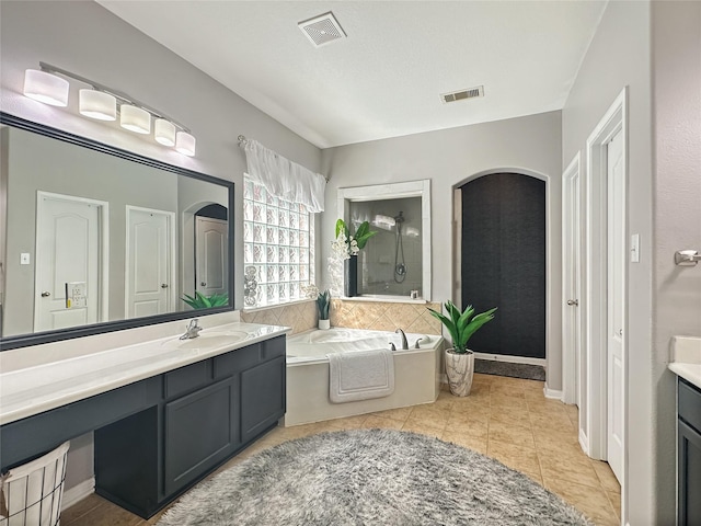 bathroom featuring tile patterned floors, visible vents, vanity, and a garden tub