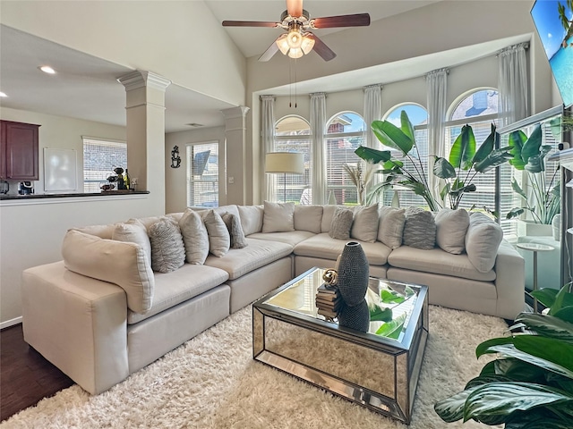 living room featuring vaulted ceiling, a wealth of natural light, a ceiling fan, and ornate columns