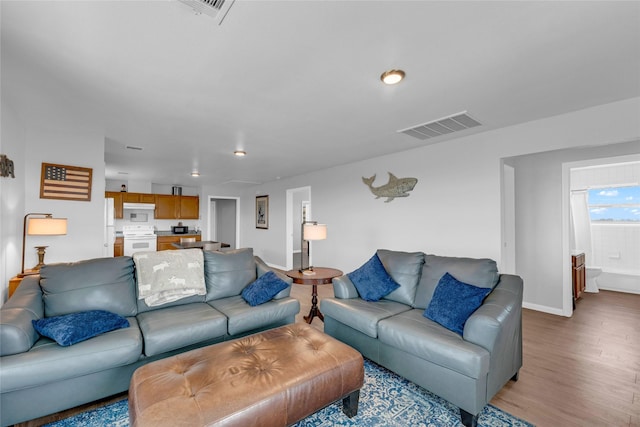 living area featuring visible vents, baseboards, and light wood-style flooring