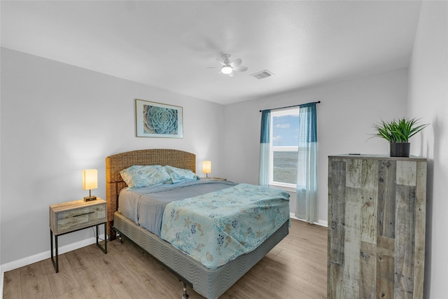 bedroom featuring ceiling fan, wood finished floors, visible vents, and baseboards