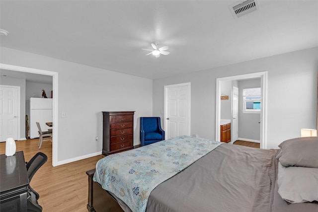 bedroom with visible vents, ceiling fan, baseboards, freestanding refrigerator, and light wood-style floors