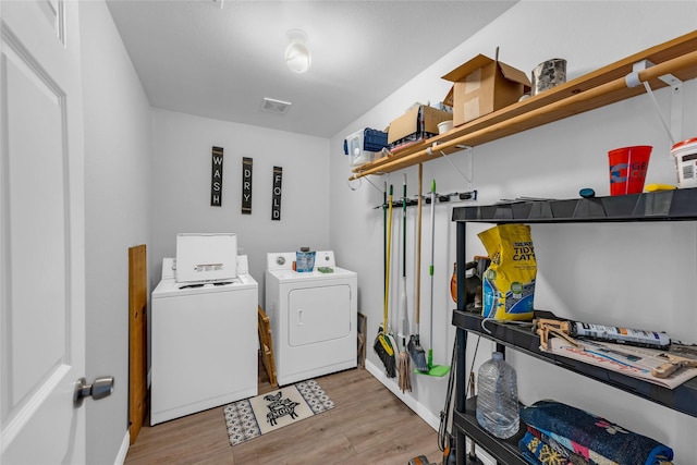 washroom featuring washer and dryer, visible vents, light wood-style floors, and laundry area