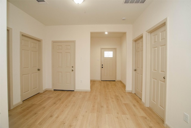 interior space with baseboards, visible vents, and light wood finished floors