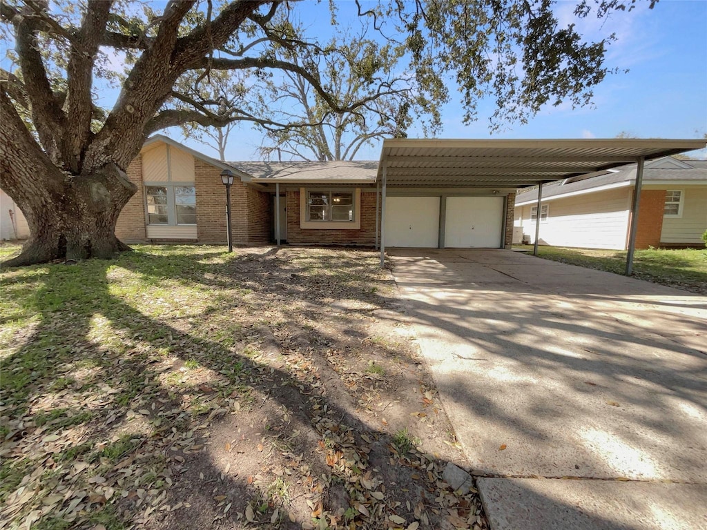 view of front of home with a carport, a garage, brick siding, and driveway