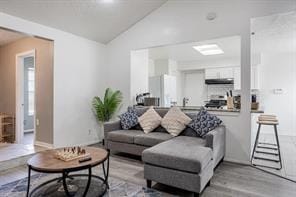 living area with lofted ceiling and light wood-style flooring