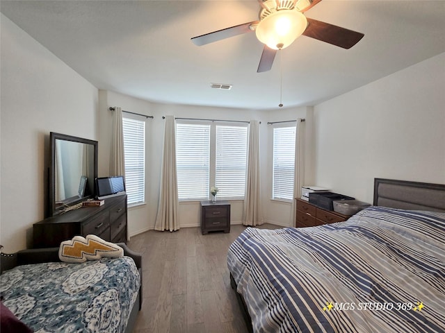 bedroom with light wood-type flooring, visible vents, baseboards, and multiple windows