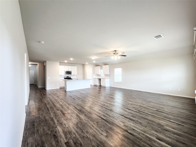 unfurnished living room with ceiling fan, recessed lighting, visible vents, baseboards, and dark wood finished floors