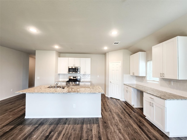 kitchen with stainless steel appliances, a sink, visible vents, and light stone countertops