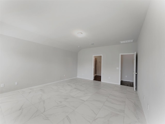 unfurnished room with vaulted ceiling, marble finish floor, visible vents, and baseboards