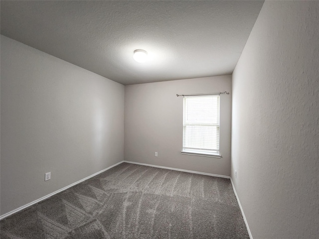 carpeted empty room featuring a textured wall, a textured ceiling, and baseboards