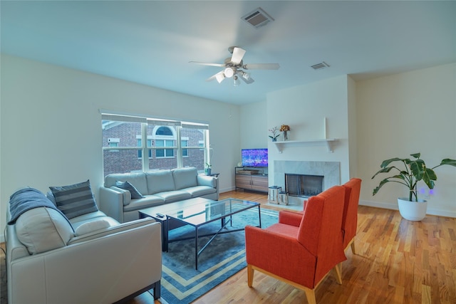 living area with visible vents, a fireplace, and wood finished floors