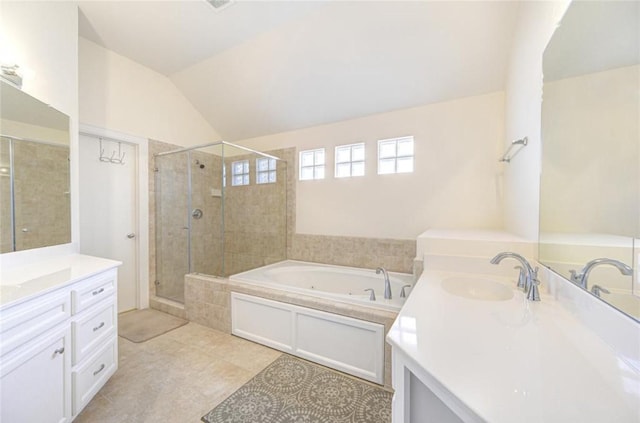 bathroom featuring two vanities, a stall shower, a sink, lofted ceiling, and a bath