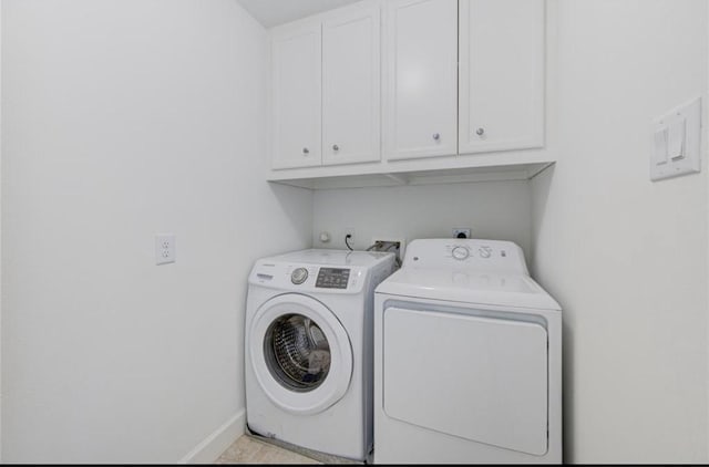 laundry area with baseboards, cabinet space, and washing machine and clothes dryer