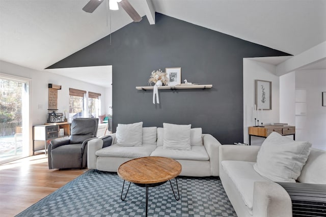 living area with vaulted ceiling with beams, a ceiling fan, and wood finished floors