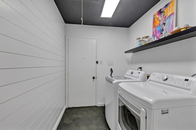 laundry room featuring washing machine and clothes dryer, laundry area, and dark tile patterned floors