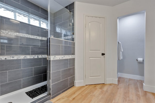 full bath featuring a walk in shower, baseboards, and wood finished floors