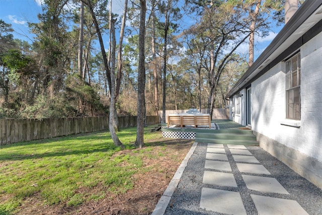 view of yard with a fenced backyard and a wooden deck