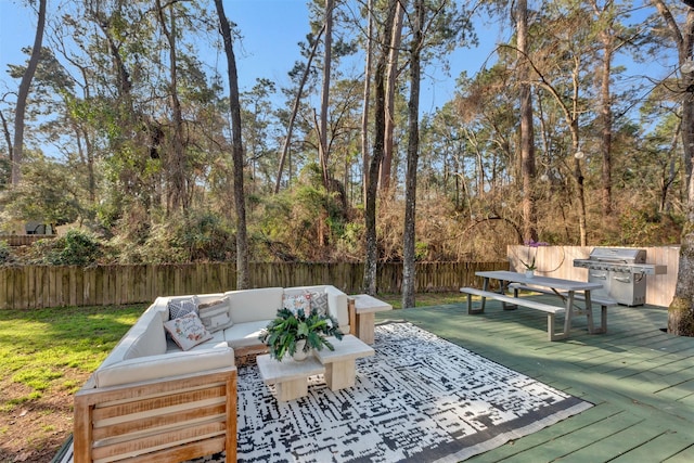 wooden terrace featuring an outdoor living space, a grill, and a fenced backyard