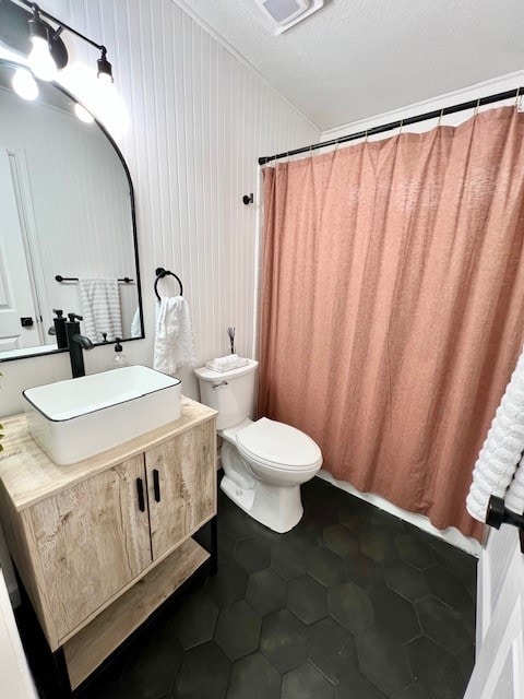 bathroom with toilet, a shower with shower curtain, vanity, tile patterned floors, and a textured ceiling