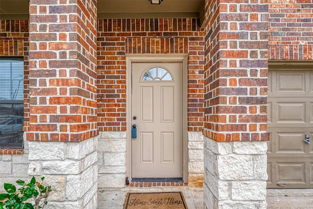 view of exterior entry with brick siding