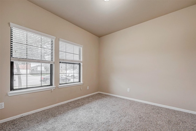 carpeted spare room with baseboards