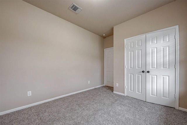 unfurnished bedroom with carpet, a closet, visible vents, and baseboards