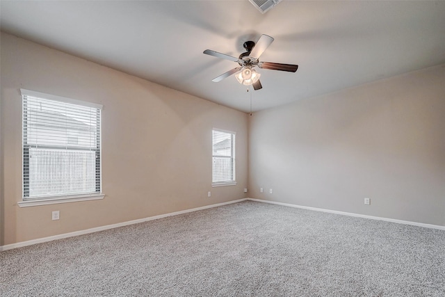 carpeted spare room featuring visible vents, ceiling fan, and baseboards