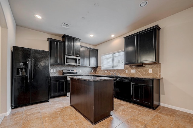 kitchen with black appliances, visible vents, backsplash, and dark cabinets