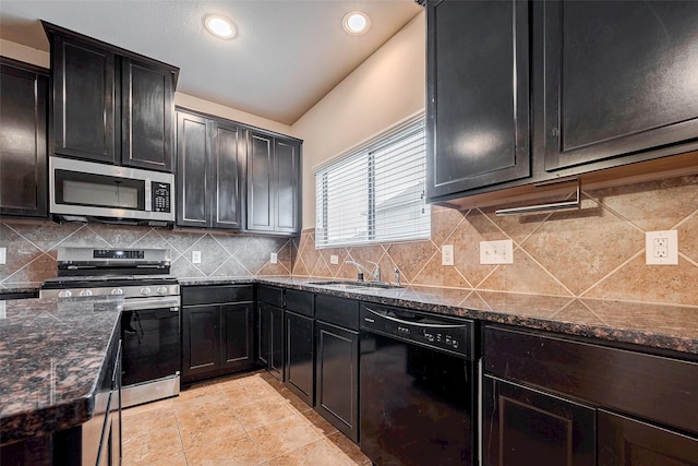 kitchen with stainless steel appliances, backsplash, light tile patterned flooring, a sink, and dark stone countertops