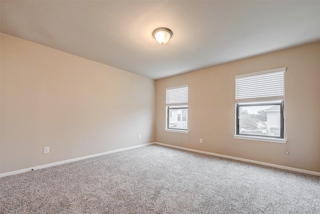 carpeted spare room with baseboards