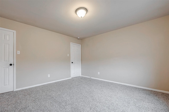 carpeted spare room with baseboards