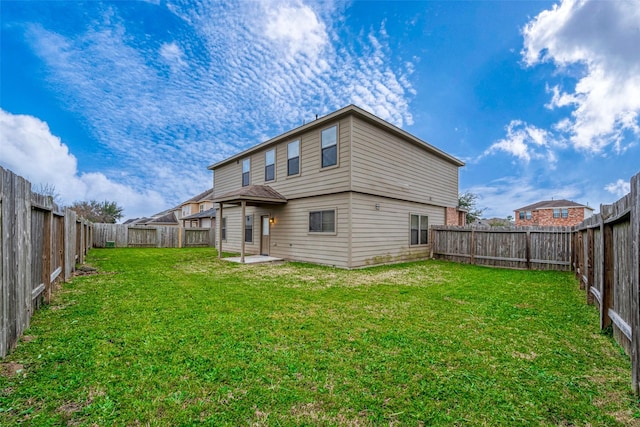 rear view of house with a patio area, a fenced backyard, and a yard